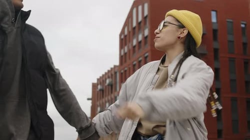 Carefree Biracial Couple Walking and Dancing on Quay