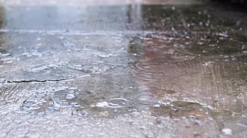 Rain Falling On Asphalt With Puddle. close up