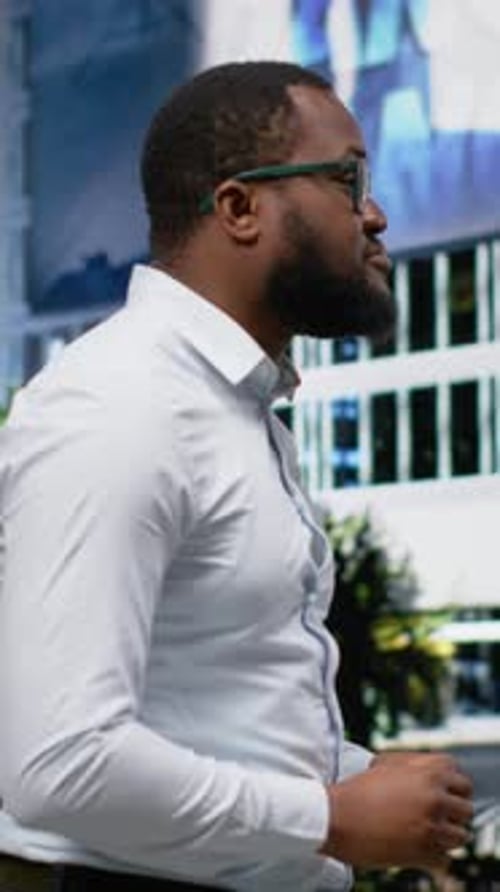 Vertical Video Black Adult Man with a Trendy Street Style Walks Under Day Sunlight