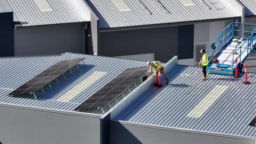 Men Working on Roof for Solar Panel Installation at Commercial Warehouse