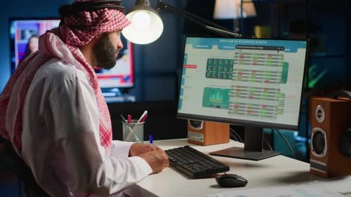 Man Working at Computer in Office at Night