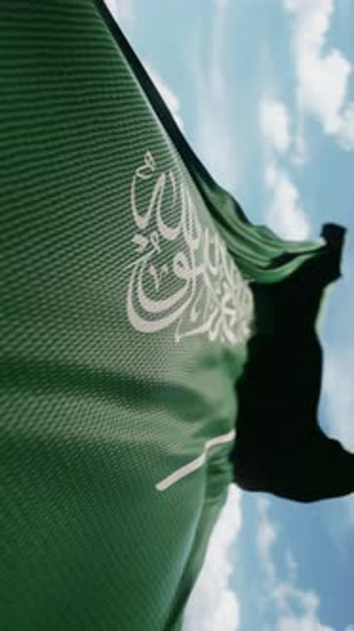 Waving Saudi Arabia Flag Against Blue Sky