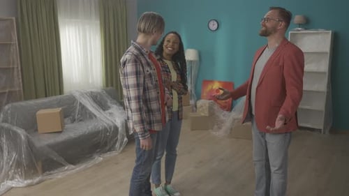 A Real Estate Agent Demonstrates an Apartment to a Couple Talks About Its Advantages Men Shake Hands
