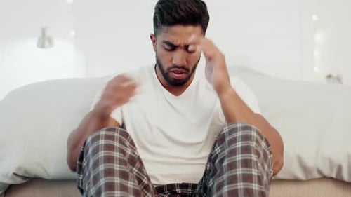 Distraught Young Adult Sitting in Bedroom