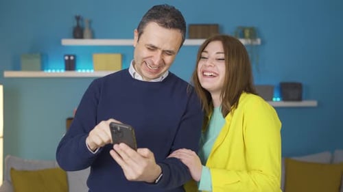 Couple Laughing Together at Mobile Phone