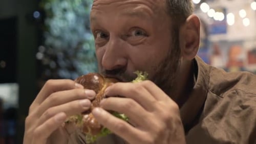 Funny, Hungry Man Eating Burger in Cafe 30s