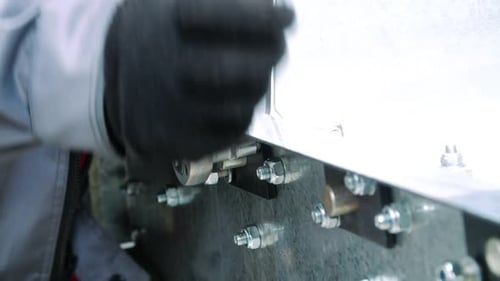 Close Up of Wrench Tightening Bolts in a Factory