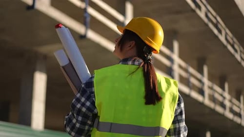 Construction Site Engineer With Plans and Hardhat