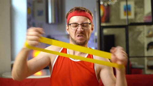 Man Exercises with Resistance Band in Home