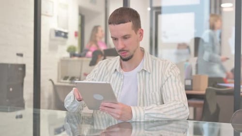 Young Adult Using Tablet in Modern Office