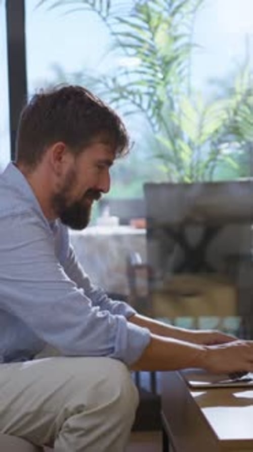 Man Typing on Laptop at Home During Daytime