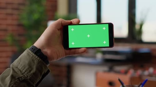 Hand Holding Mobile Device with Green Screen Display