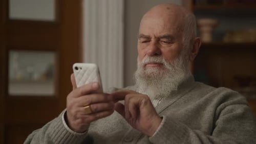 Senior Man Using Mobile Phone Indoors