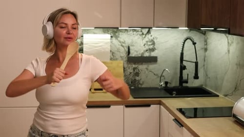 Woman Listening to Music and Dancing in Kitchen