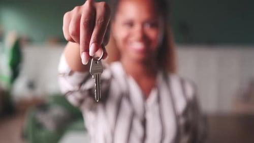 Smiling Woman Showing Keys in Home