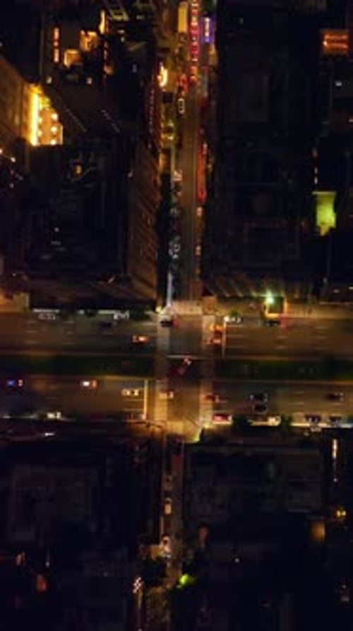 Looking at the roofs of New York buildings. Busy lively traffic along the well-lit streets