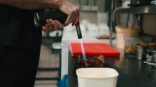 Chef Using Blowtorch to Prepare Food in Kitchen