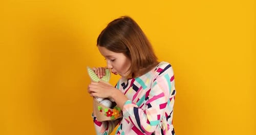 Happy playful teenager girl with painted Easter eggs on basket