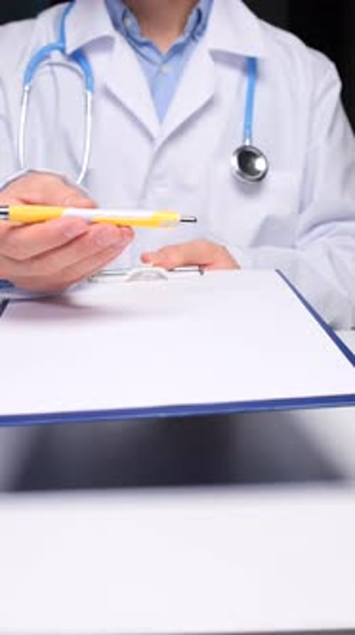Doctor Holding Clipboard and Pen in Clinical Setting