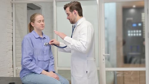 Doctor Examines Young Woman with Stethoscope in Clinic