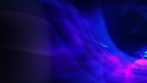 ein verschwommenes Bild von blauen und violetten Strähnen, die auf dem Hintergrund wirbeln