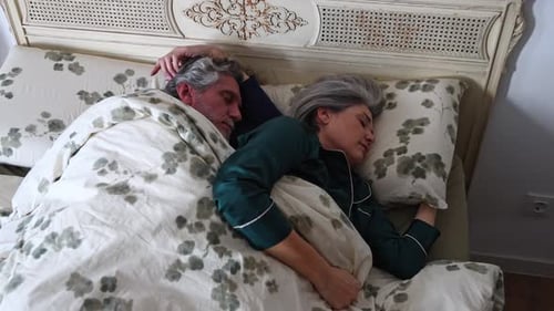 Senior Couple Peacefully Sleeping Together in Bed