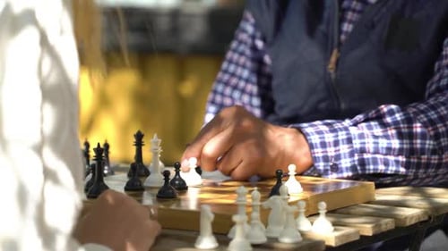 People Playing Chess Game at Outdoor Table