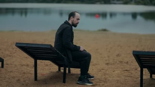 Man Sitting on Beach Alone Deep in His Feelings and Sadness
