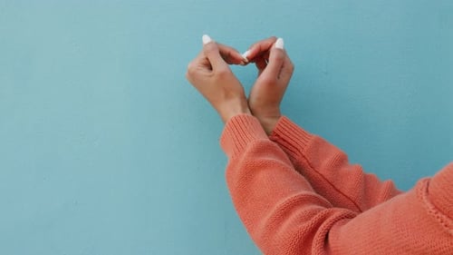 Woman Creates Heart Shape with Hands Against Blue