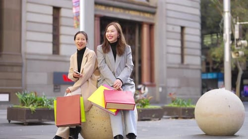 Азиатские подруги в формате 4K вместе делают покупки в городе.