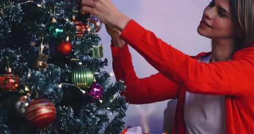 Woman Decorating Christmas Tree with Ornaments