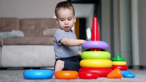 Un precioso niño caucásico construye una pirámide de juguete. Niño feliz que crece y se desarrolla.