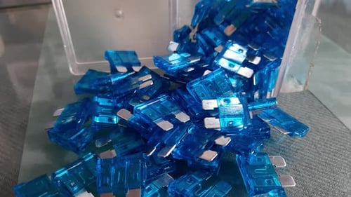 Blue automotive type blade fuse 25AMP, A set of colored electronic blade fuses. Plastic parts of an