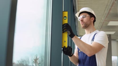 A Repairman in Uniform Installs Pvc Windows in New Office