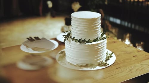Elegant White Wedding Cake with Green Decorations