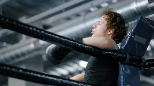 Sad kickboxer portrait losing fight at gym emotional upset athlete on ring ropes