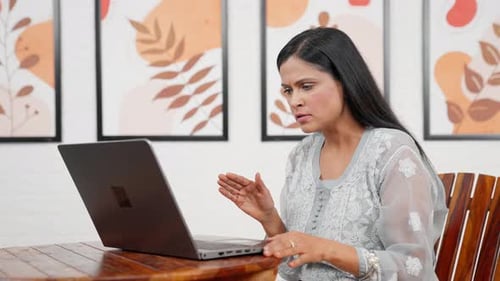 Woman Video Conferencing on Laptop at Home