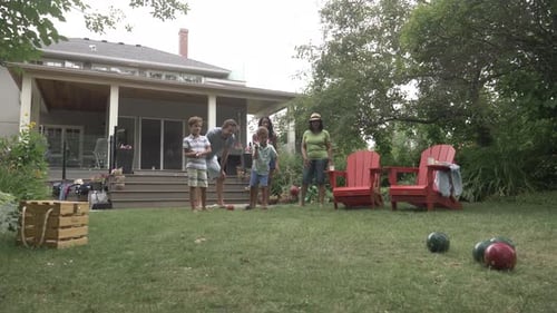Of Family Playing Lawn Bowl in Backyard