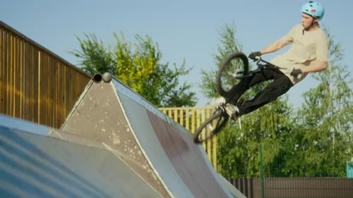 BMX Athlete Performing Air Trick on Bike above Ramp at Skatepark