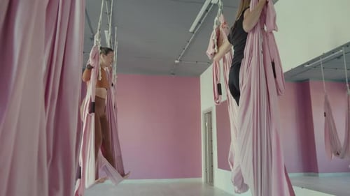 Women Practicing Aerial Yoga in Studio