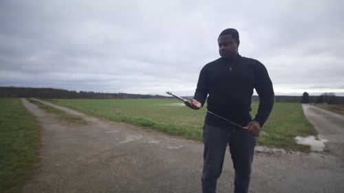 Modern Black Swordsman Warrior Awaiting Battle Opponent in Open Field Under Grey Sky, Europe, 4K Mus