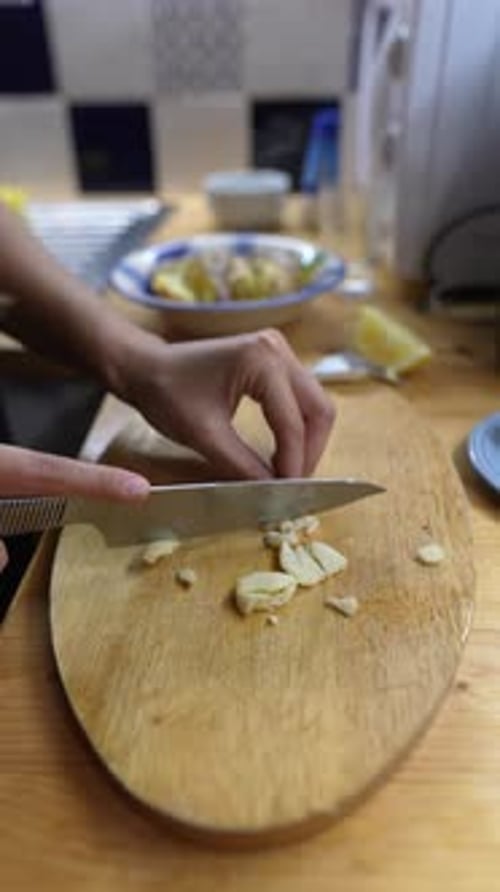 Chopping Garlic Mastering Culinary Preparation Techniques in a Cozy Welcoming Kitchen Environment