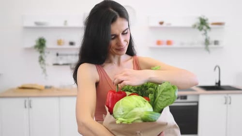 Sporty Woman with Bag Full of Products Standing in Kitchen