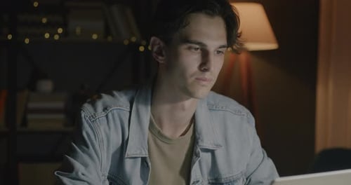 Young Adult Working on Laptop at Night