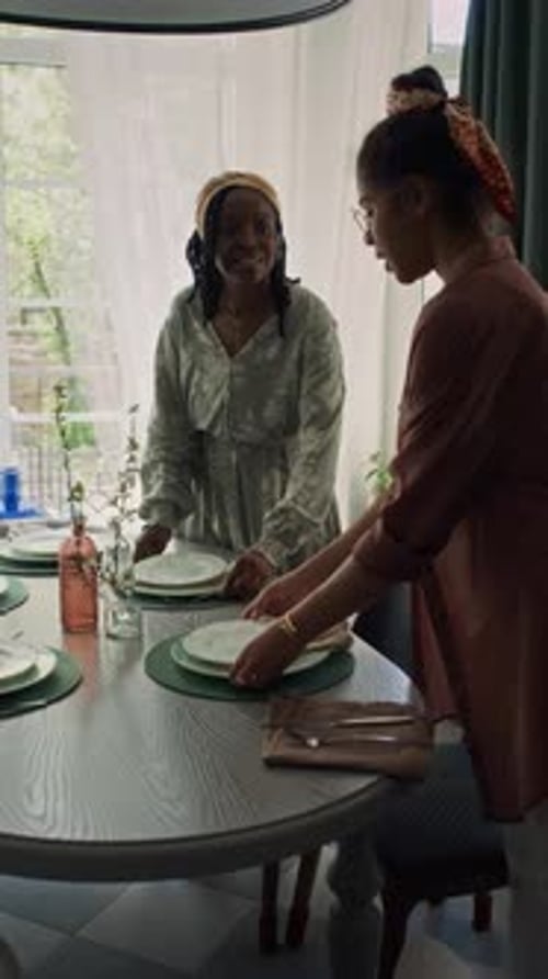 Women Setting Table for Dinner Together Indoors