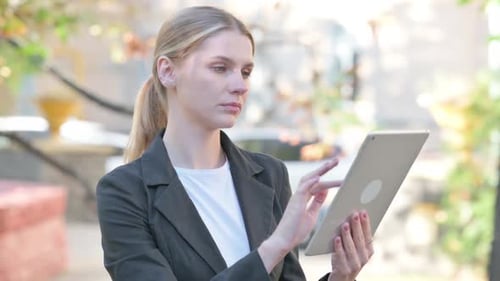 Woman Interacting with Tablet Device Outdoors