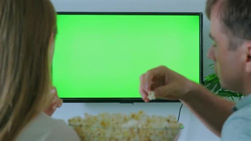 Couple Enjoying Popcorn While Watching Television with Green Screen