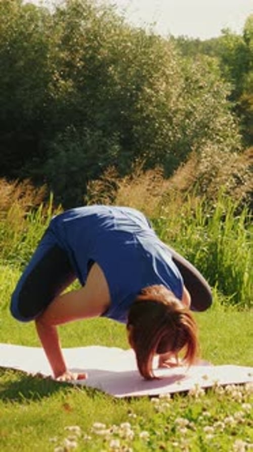 Woman failed yoga pose. Female practicing yoga asanas in park. Vertical video
