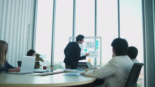 Business Presentation by Young Man to Colleagues in Office
