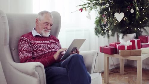Senior man using tablet at Christmas in home